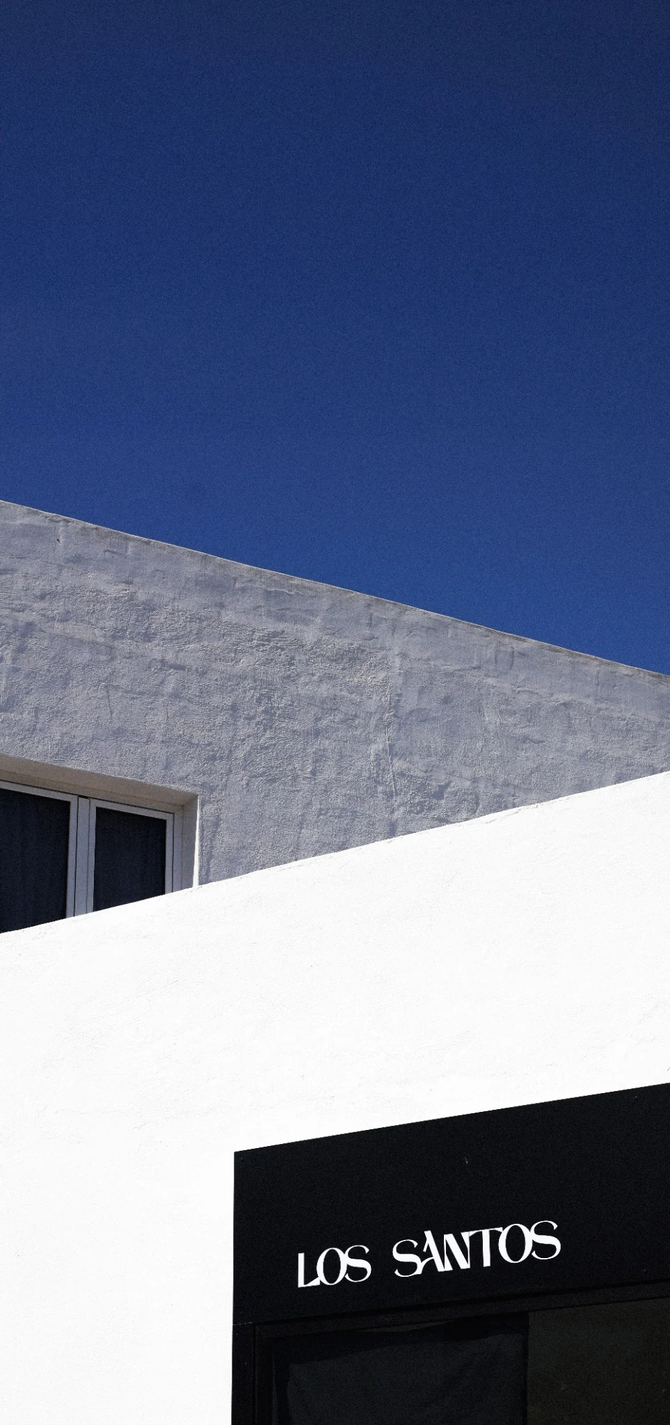 Vista verticale di architetture bianche e grigie contro il cielo blu di Lanzarote.